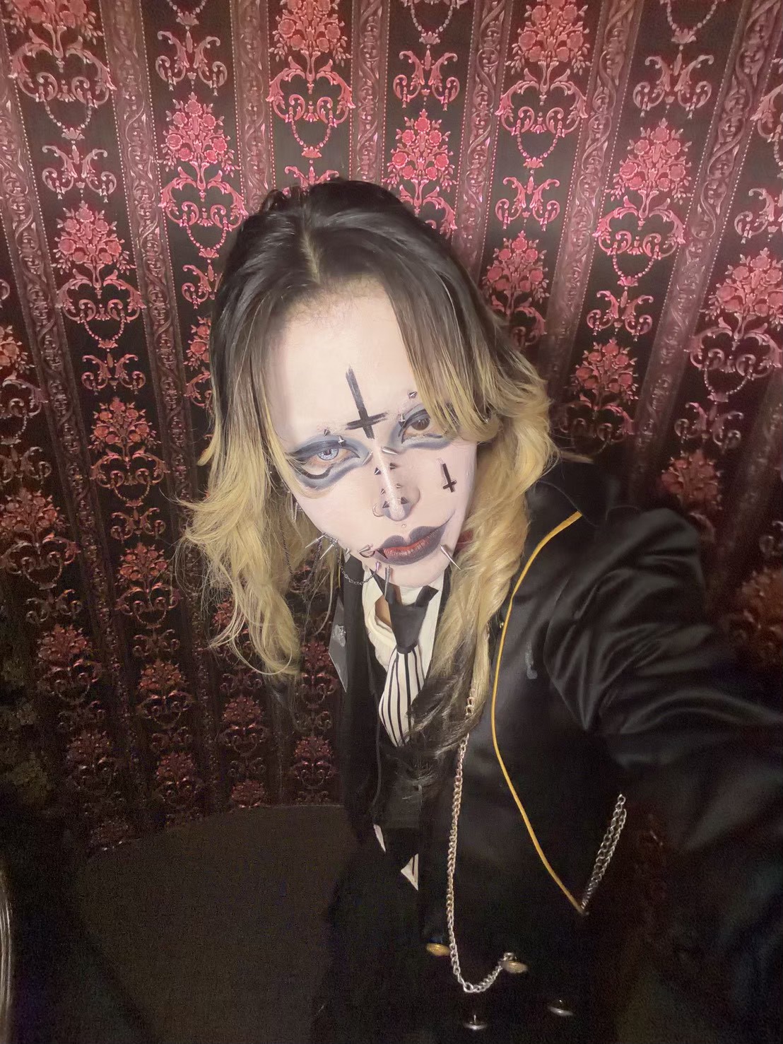 赤と黒の壁紙を背景に黒い制服をまとったメシアさん